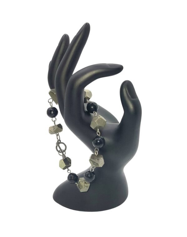 Handcrafted Black Onyx and Pyrite bracelet with natural stones, promoting protection, healing, abundance, and spiritual growth for emotional stability and prosperity